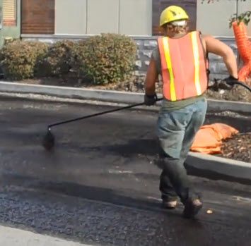 Paving contractor applying asphalt tack coat on parking lot in St Louis