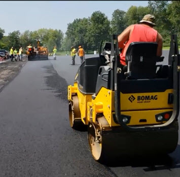 Asphalt paving company compacting new asphalt parking lot in St Louis MO